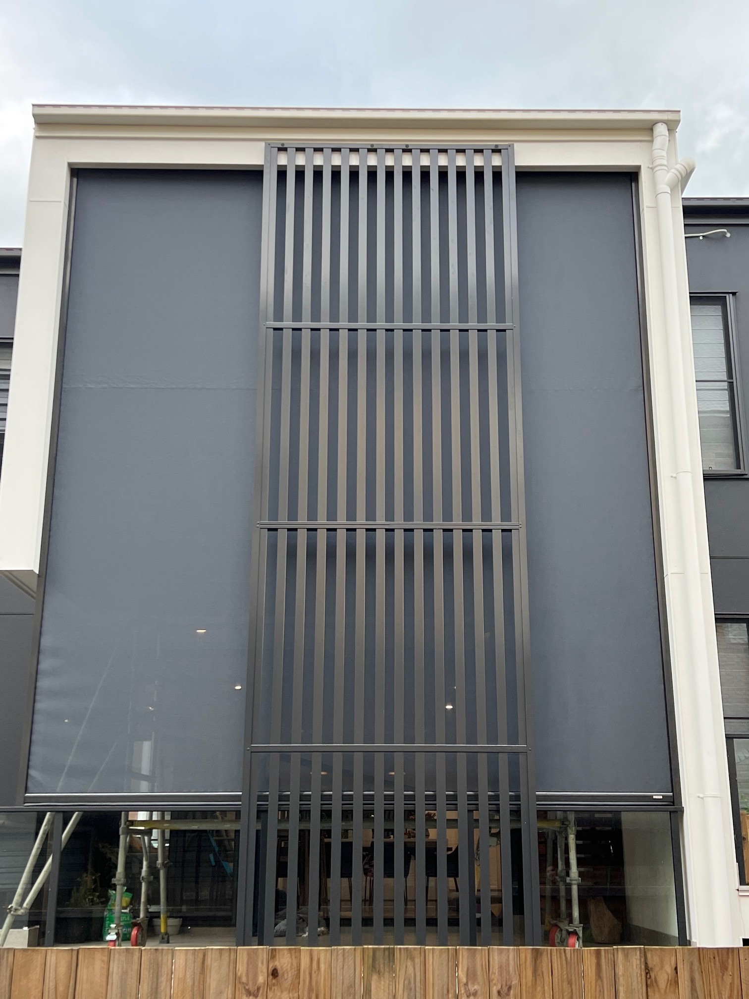 Double-storey motorised outdoor screens on a modern Sunshine Coast home