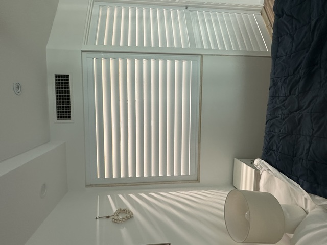 White plantation shutters fitted to a Sunshine Coast window